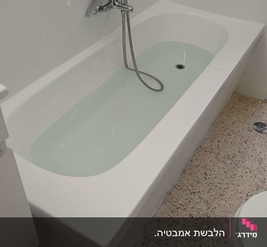 אמבטיה עם מים וברז מותקן על קיר